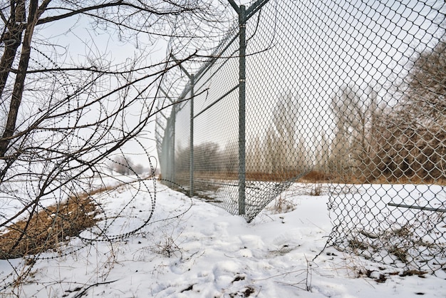 Escape from prison or closed institution for mentally ill hole in border fence with barbed wire unau...