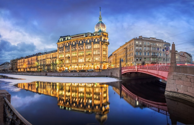 Esders and Scheufals store building and reflection in the water of the Moika River in St. Petersburg