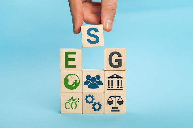 Esg concept of environmental social and governance words esg on a wood cubes hand holds wooden cube