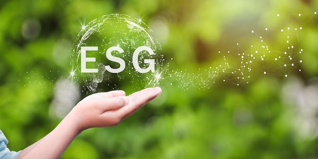 ESG icon concept in the hand for environmental social and governance in sustainable and ethical business on the Network connection on a green background