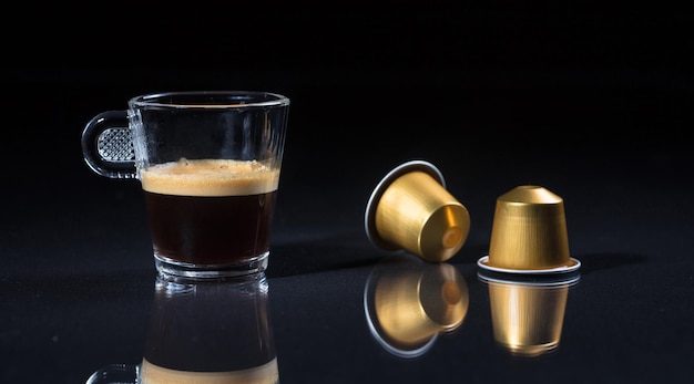 Espresso coffee cup and coffee pods on black background Closeup view with details