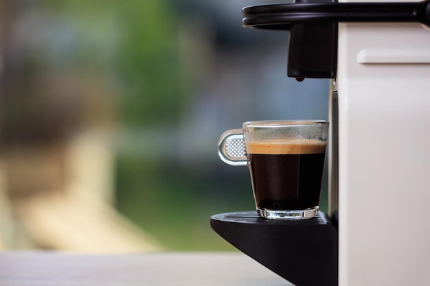 Espresso coffee machine on a blur green background space for text