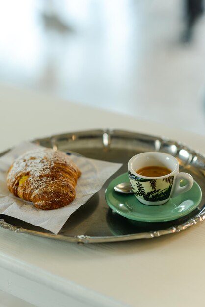 Espresso coffee orange juice and custard pastry cream croissant at the bar for breakfast