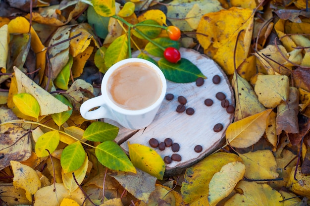 Espresso coffee in a white cup on a wooden stump 