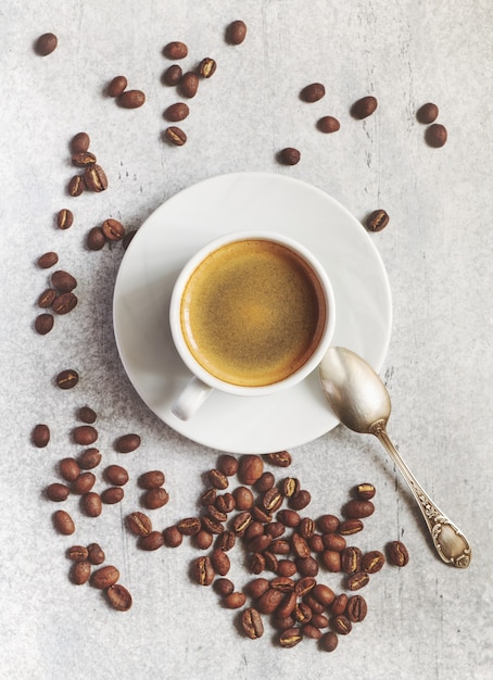 Espresso cup on a saucer with freshly roasted coffee beans