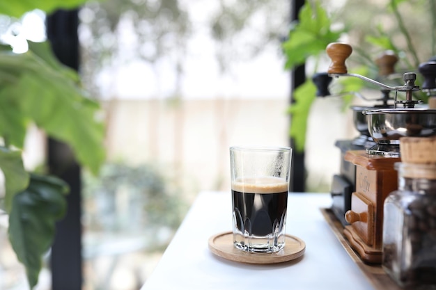 Espresso glass cup on wooden tray on white table