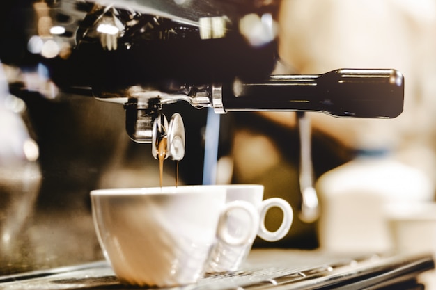 Espresso machine brewing a coffee. Coffee pouring into glasses in coffee shop, espresso pouring from coffee machine