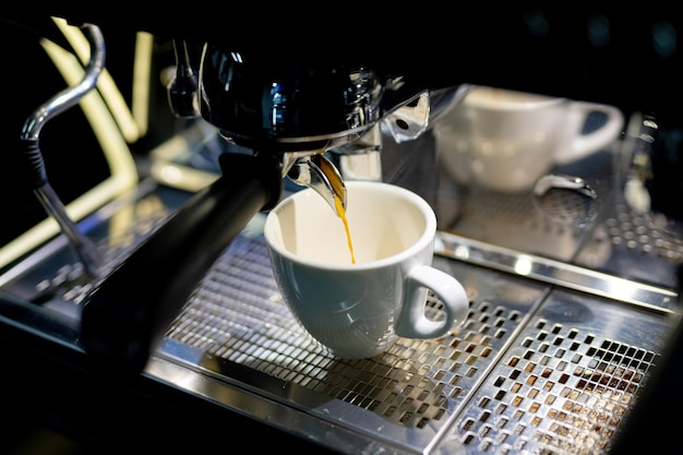 Espresso making with milk in cafeteria. Coffeemaking by barista in reataurant.