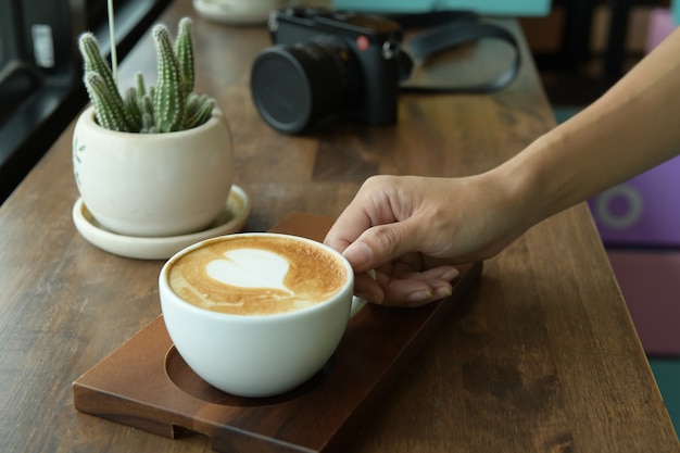 Espresso in white coffee cup with brown wooden table background