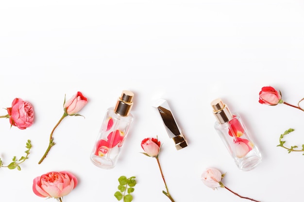 Essential aroma oil with roses on wooden background beauty workspace with roses cosmetics top view f