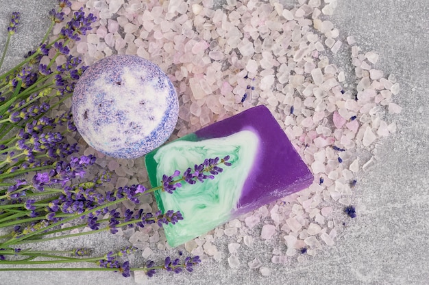 Essential lavender salt, soap and bath bomb with flowers top view. SPA lavender products.