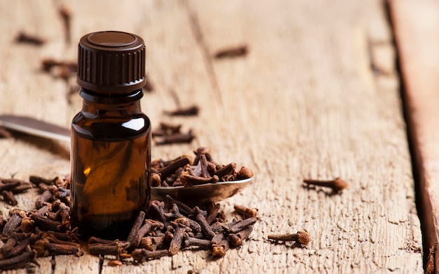 Essential oil of cloves brown bottle old wooden background selective focus