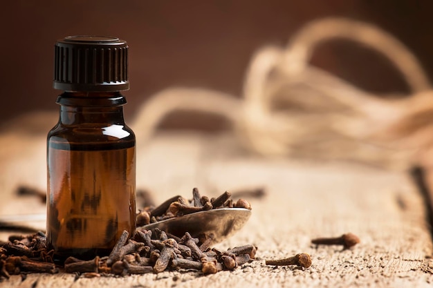 Essential oil of cloves brown bottle old wooden background selective focus