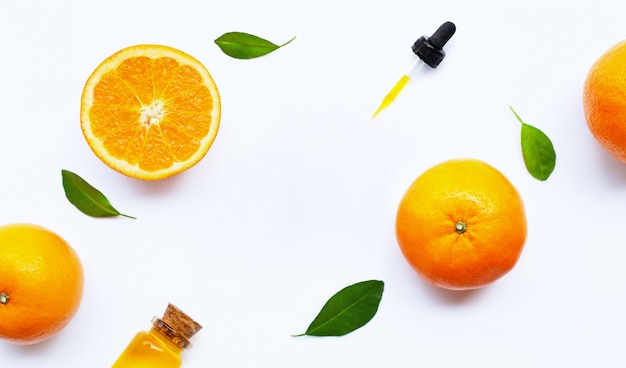 Essential oil with oranges on white.