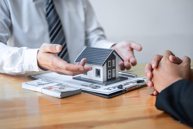 Estate agent are presenting home loan and giving house to client after discussing and signing agreement contract with approved application form Home Insurance and Real estate investment concept