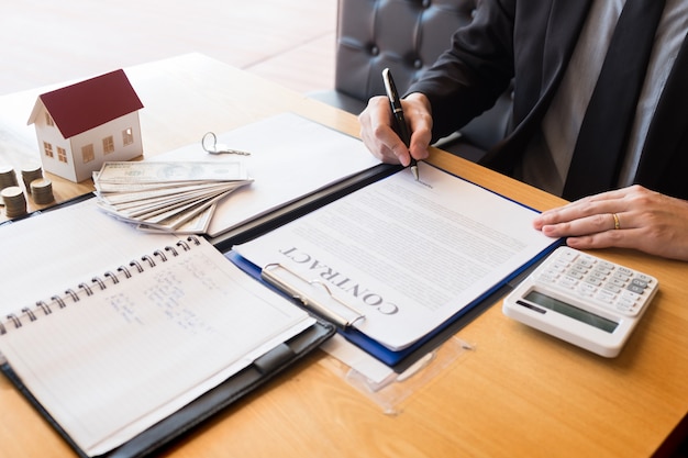 Estate agent giving house keys customer sign agreement property for sale