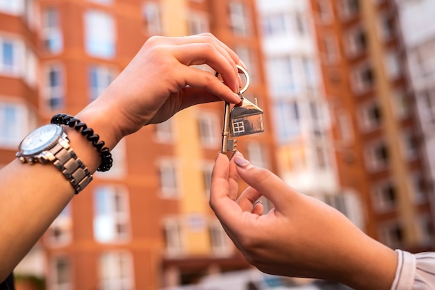 Estate agent handing house key  for the new owner on home. sale or rent home