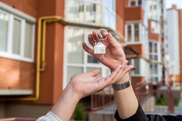 Estate agent handing house key  for the new owner on home. sale or rent home