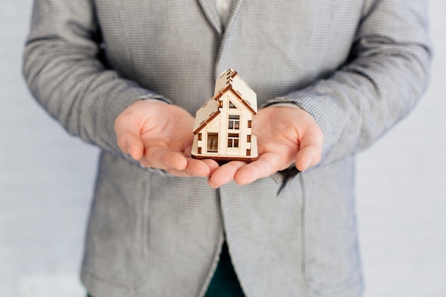 Estate agent holding wooden figurine