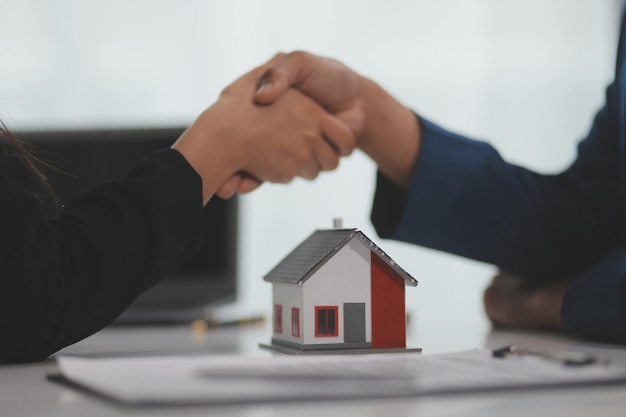 Photo estate agent shaking hands with customer after contract signature