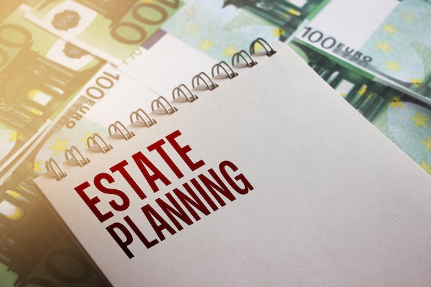 Estate Planning written on page of copybook put on 100 Euro banknotes Real estate bent and buy business concept