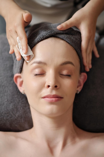 Esthetician Wiping Face of Client