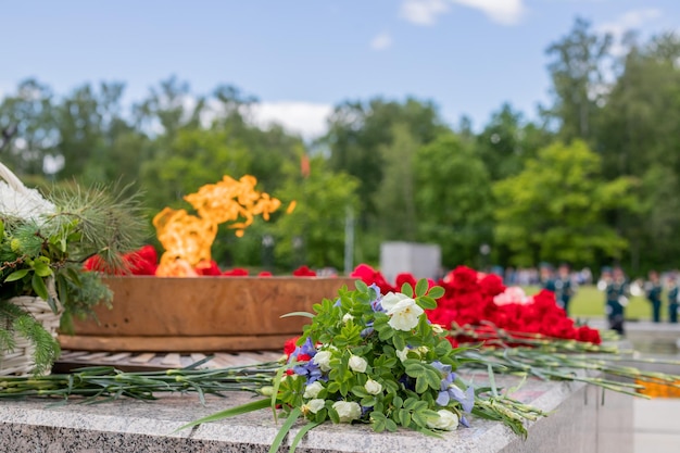 Eternal flame of the monument of the war A symbol of memory of the people about the fallen heroes May 9 Victory Day Selective focusFlowers at memorial to tomb of Unknown Soldier