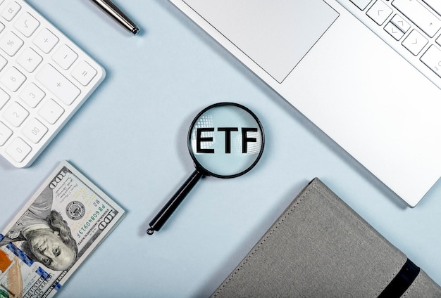 ETF investing concept Abbreviation through magnifier on office desk