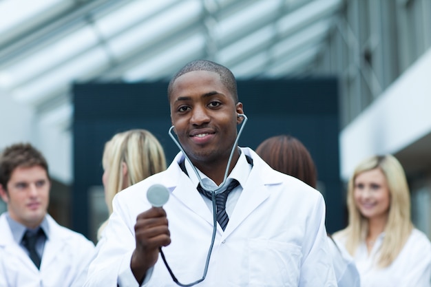 Ethnic doctor with his team in the background