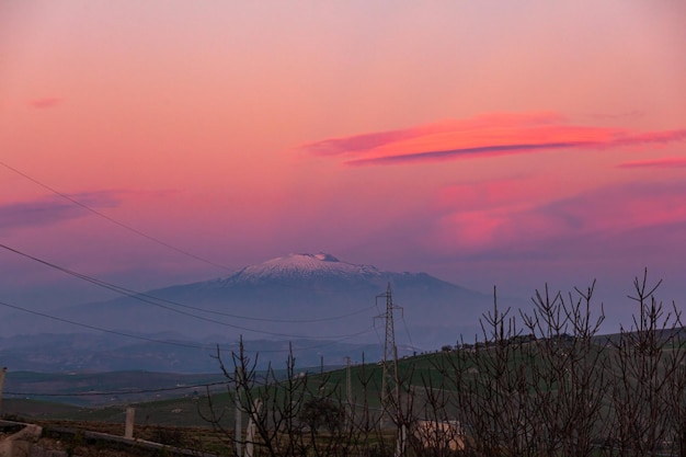 Etna volcano on pink sky at sunset seen from central Sicily