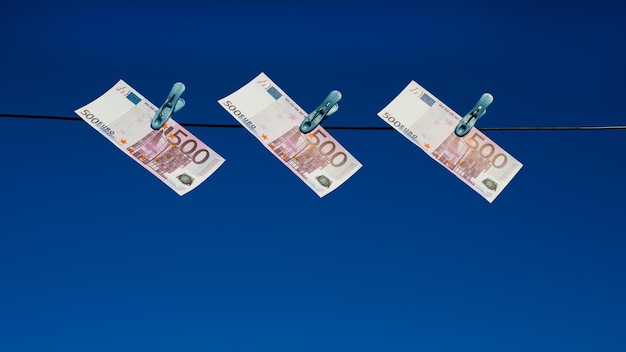 Euro banknotes hang on the ropes Euro money with clothespins on a rope Money laundering in euros was sent to dry Isolated euro money on a line