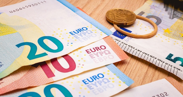 euro banknotes on the table in closeup photo with a euro coin in the composition