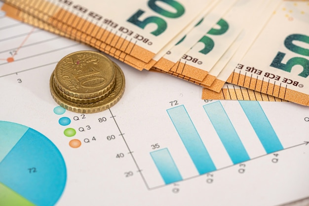 Euro coin and bills with calculator on chart with stock market prices. Business concept