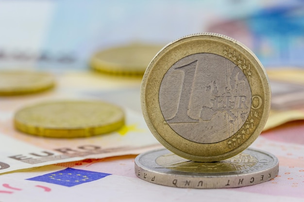 Euro coin on edge on banknotes