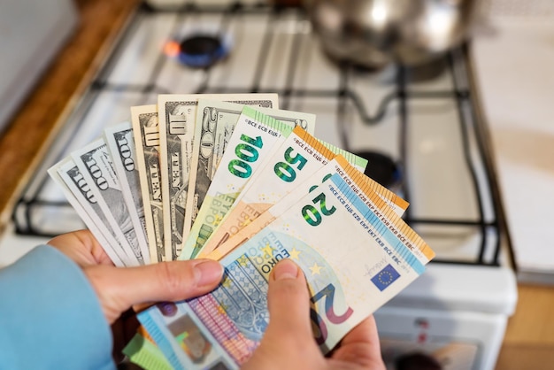 Euro and dollar banknotes on the background of a burning gas burner Concept of increasing cost of supply energy crisis High cost the price of gas