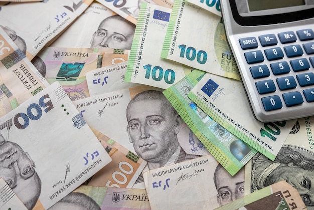 Euro and hryvnia are scattered around table with a calculator to determine the exchange rate