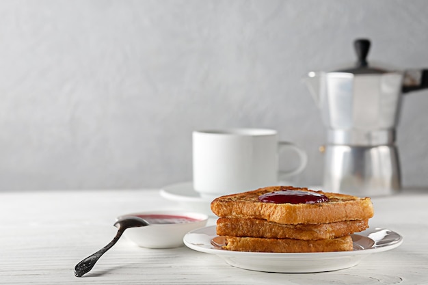 European breakfast Toasted bread with jam and a cup of hot coffee on a wooden table