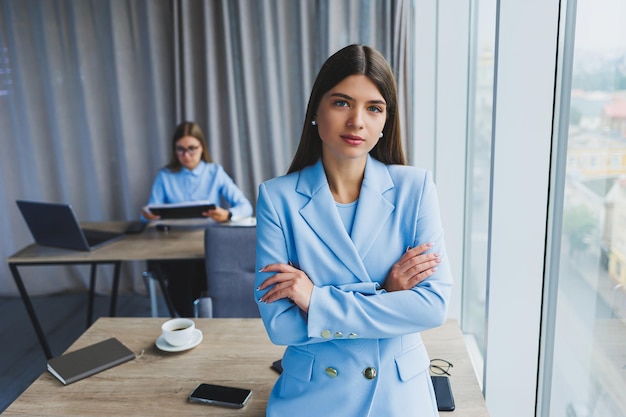 European businesswoman while working in the office Young serious Millennial brunette woman in a jacket The concept of freelance and remote work Modern women's lifestyle