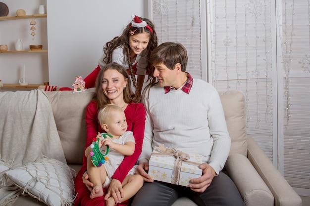 European family sitting on the sofa with Christmas gifts