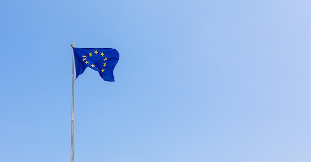 European Union EU flag is flying on blue sky background Banner place for text