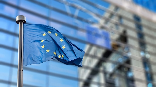 The European union flag is waving in front of a building