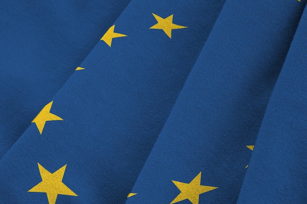 European union flag with big folds waving close up under the studio light indoors The official symbols and colors in banner