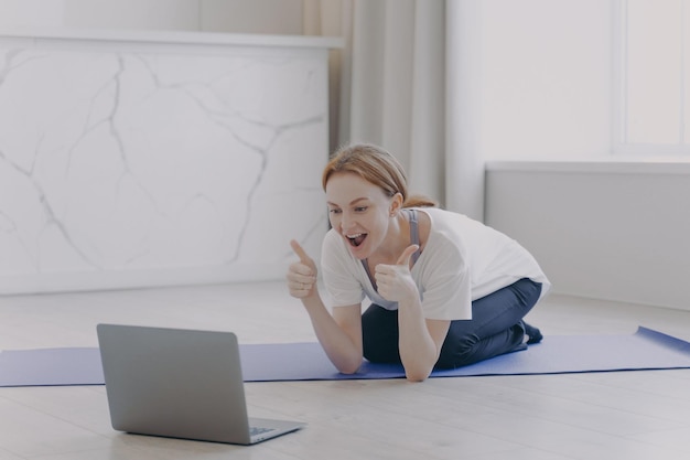 European white woman has distance sport classes Girl gestures thumbs and feels good