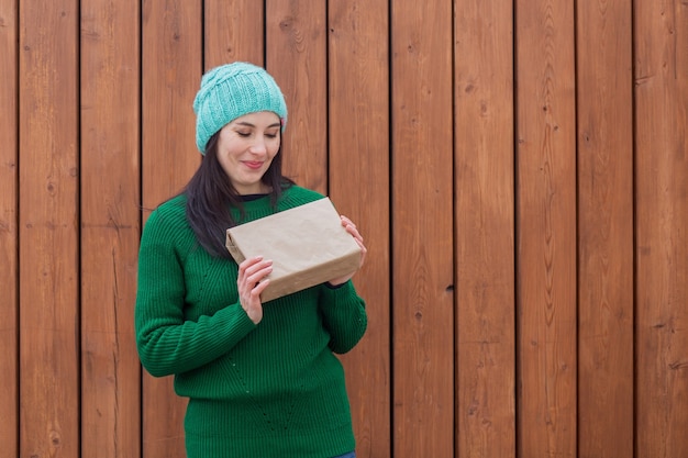 European woman in green sweater with gift. 