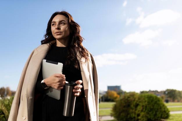 European woman model with a tablet in her hands in the spring on the street