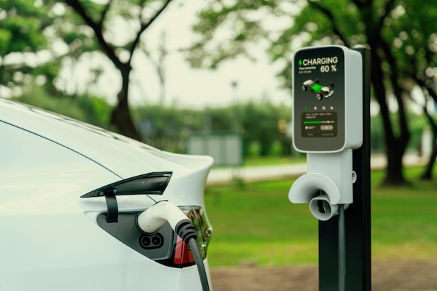 Photo ev vehicle recharging from ev charging station in green city park exalt