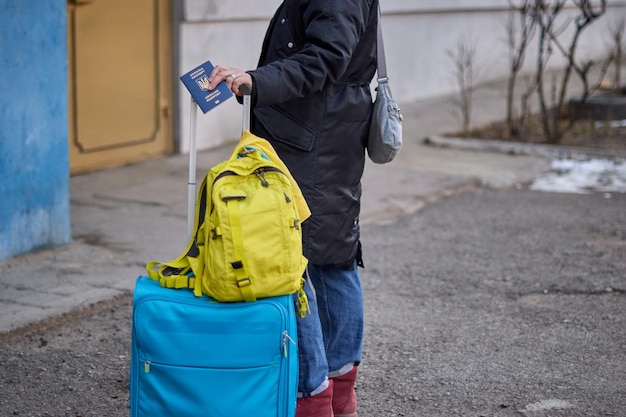 Evacuation of civilians sad child holding a passport with yellowblue flag Stop war