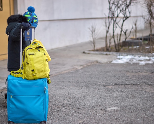 Evacuation of civilians sad child holding a passport with yellowblue flag Stop war