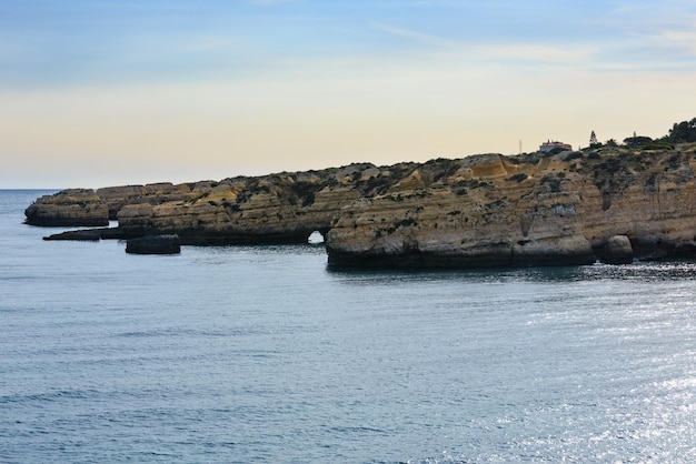 Evening Atlantic rocky coast landscape, Albufeira, Algarve, Portugal. Fishermen are unrecognizable.