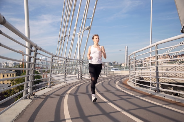 Evening jogging workout of young woman in city